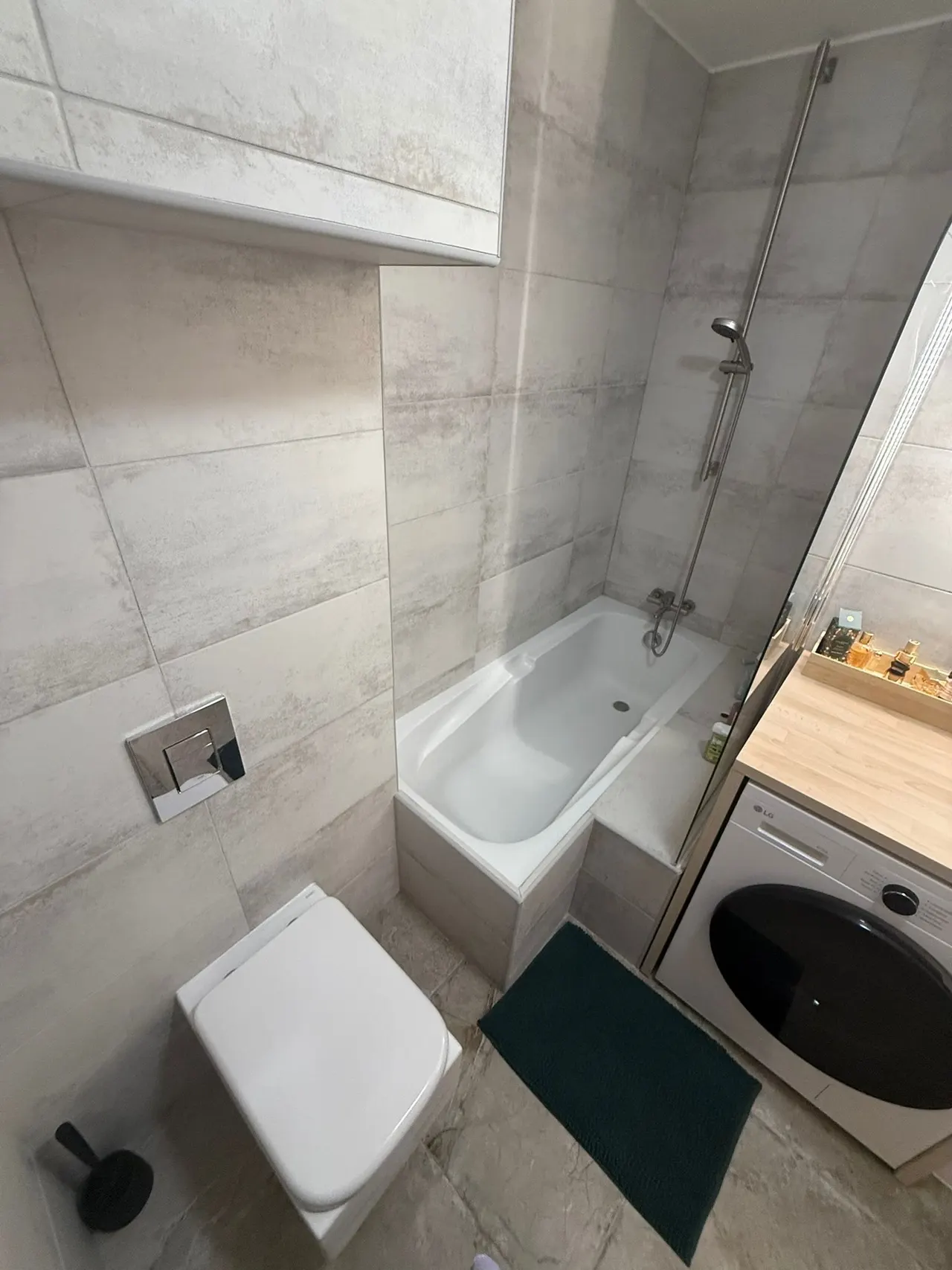 Wand-WC und Betätigungsplatte in einem renovierten Badezimmer montiert.